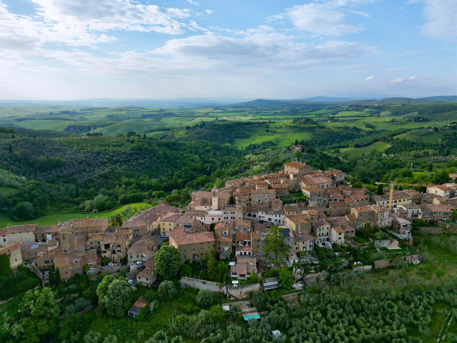 Hilltop village surrounded by rolling green countryside, photographed from the air