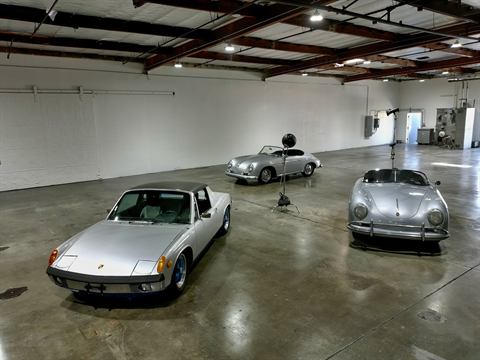 Two silver vintage Porsches, a 914 and a 356, staged in a bright studio garage