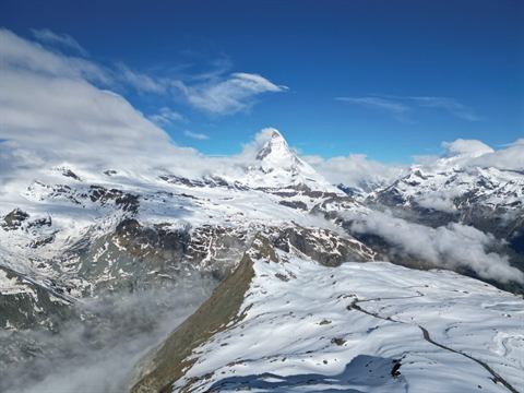The Matterhorn above snow-covered glaciers and drifting clouds