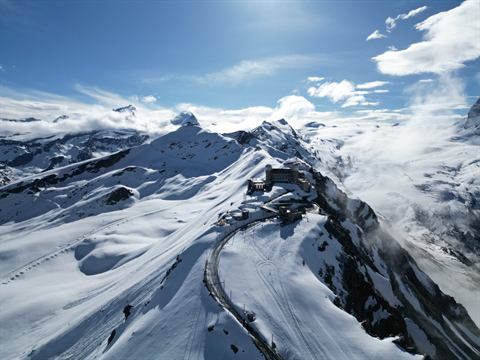 Snowbound alpine ridge with a mountain road carved across it