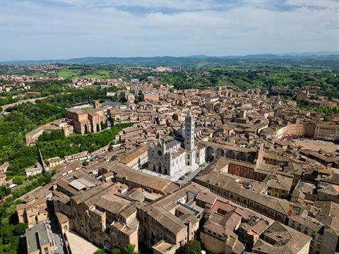 Aerial of a medieval Italian hill town and its cathedral in soft morning light