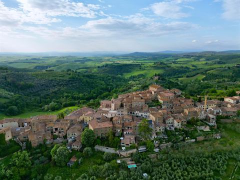 Hilltop village surrounded by rolling green countryside, photographed from the air