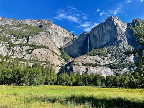 Yosemite Falls dropping to a green valley meadow