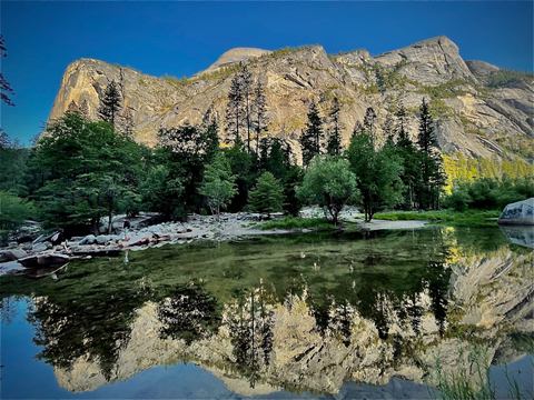 Granite cliffs mirrored in the still water of Mirror Lake, Yosemite