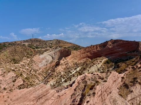 Red-rock ridgeline rising from desert scrub under a clear sky