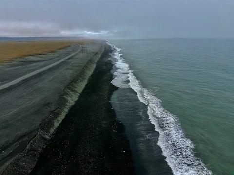 Waves washing a black-sand beach on Iceland's south coast, from above